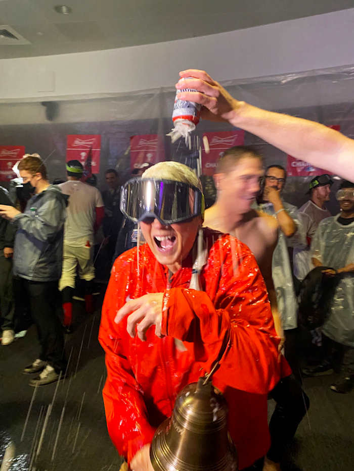 Sheree McMullen holds the Phillies’ liberty bell as she gets drenched with beer during the team’s celebration after clinching a trip to the World Series.